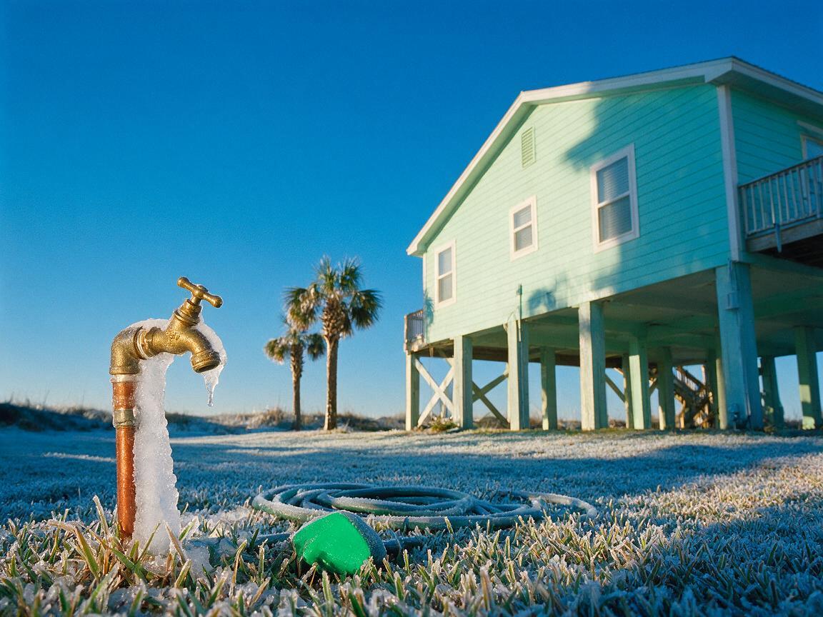Iced hose bibb on a Panama City Beach cottage after a hard freeze, why to prevent frozen pipes